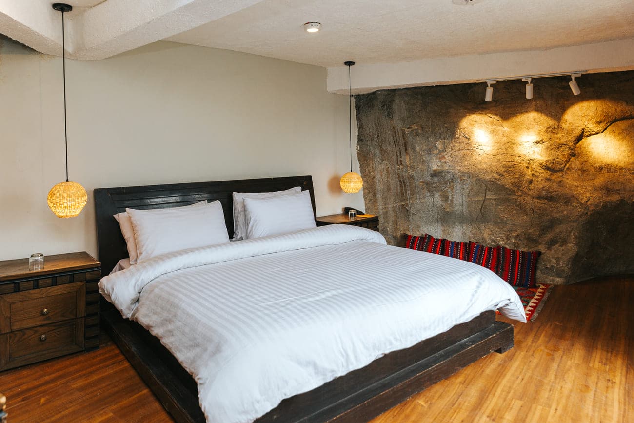 King bedroom with stone feature wall and warm lighting
